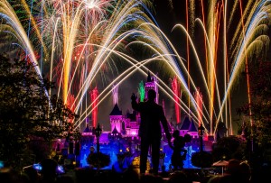 "Dreams Come True" fireworks display over the Sleeping Beauty Castle at Disneyland with Walt and Mickey's statue in front.
